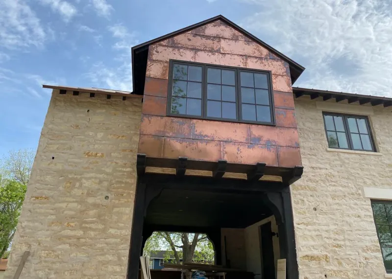 Copper metal panel facade on a stone building for Roof Repair in Portales